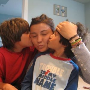 Jungen geben Frau Küsschen auf die Wangen