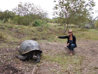 Eine junge Frau hockt neben einer Schildkröte