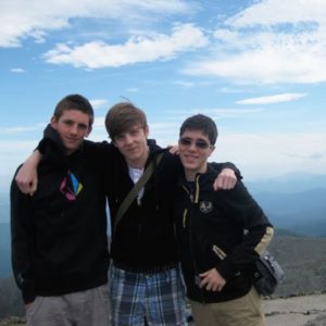 Gruppenbild von drei Jugendlichen mit Bergen im Hintergrund